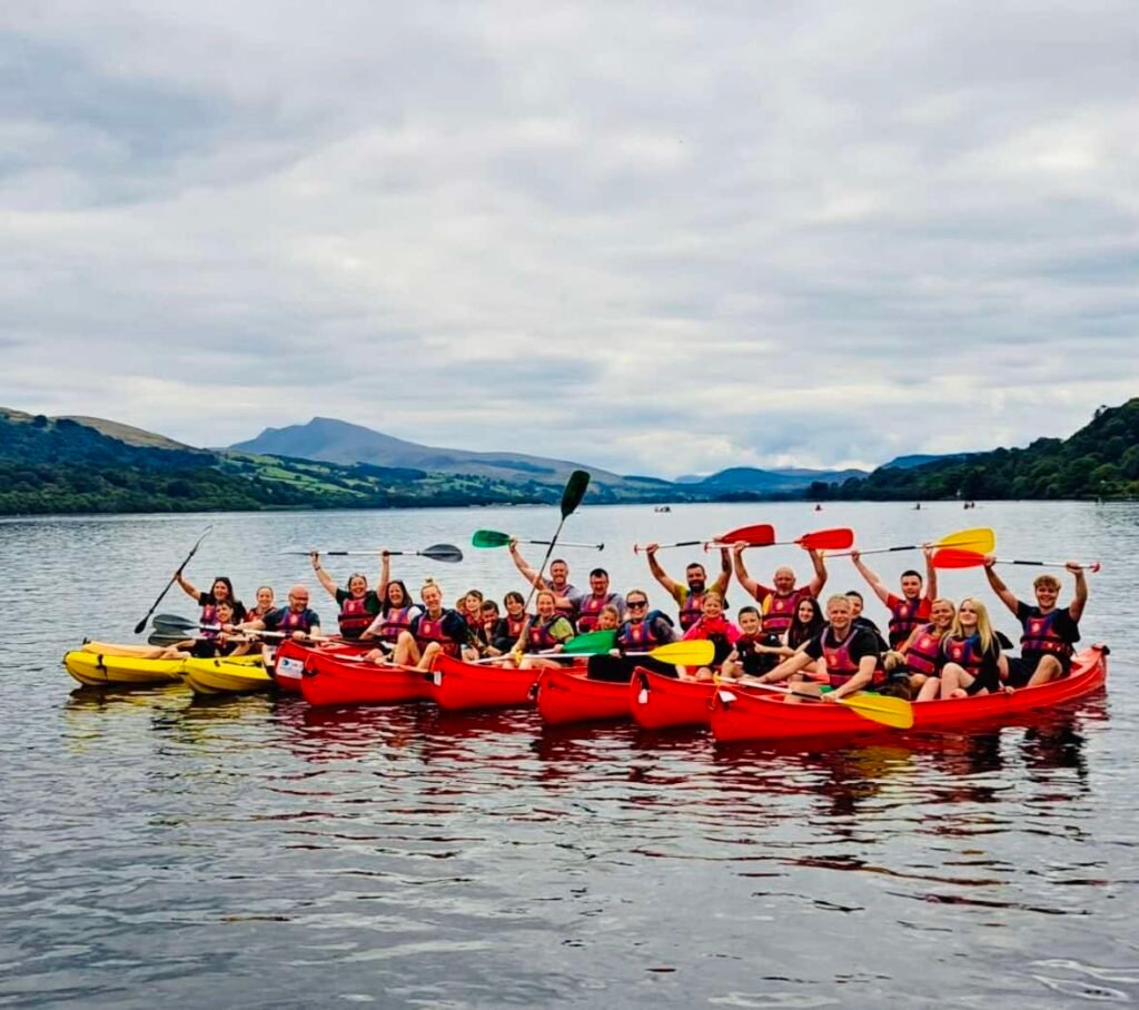 Image of group of people on Bala Lake, canoeing, huddled together for a photo