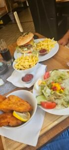 Burgers, chips and salads on a restaurant table in Austria